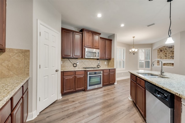 kitchen featuring an inviting chandelier, stainless steel appliances, light hardwood / wood-style floors, and sink