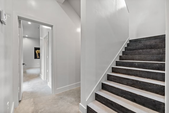 staircase featuring concrete floors