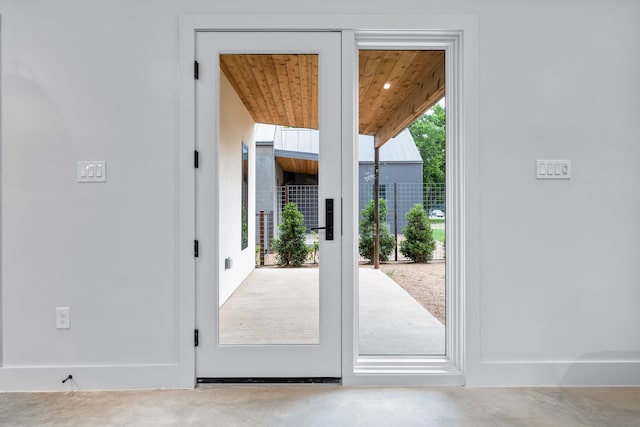 entryway with wood ceiling and concrete floors