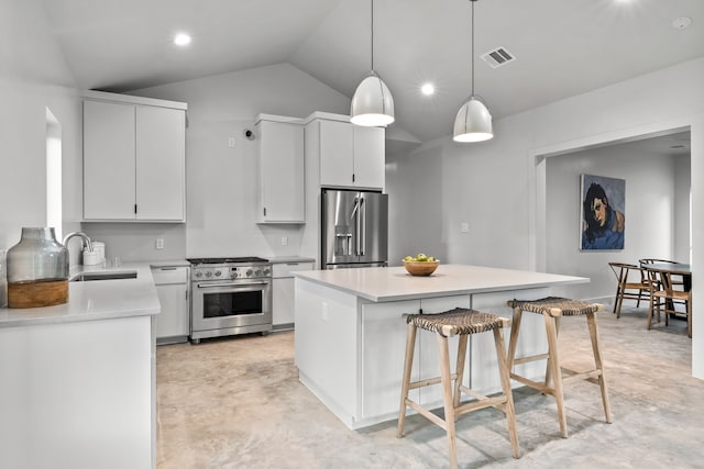 kitchen with appliances with stainless steel finishes, a center island, sink, lofted ceiling, and white cabinets