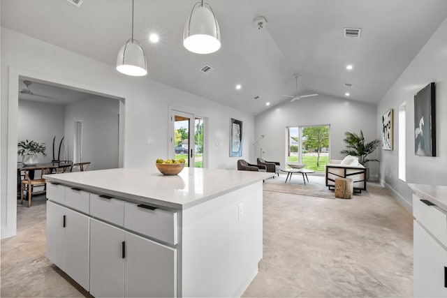 kitchen with white cabinetry, a kitchen island, ceiling fan, hanging light fixtures, and lofted ceiling