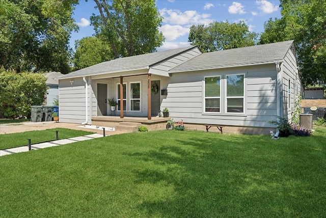 ranch-style home featuring covered porch, central AC unit, and a front lawn