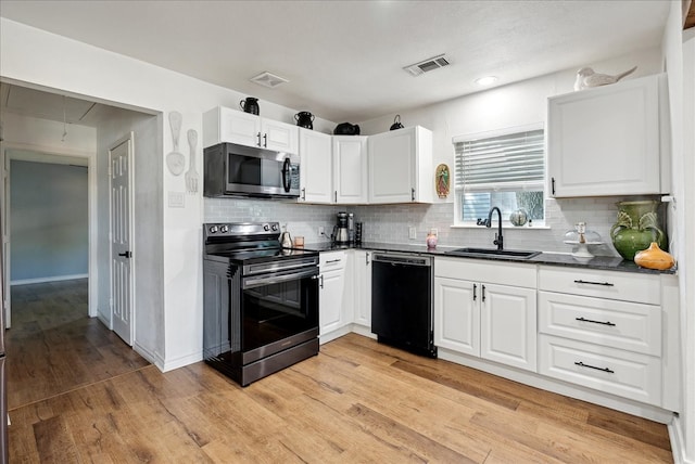 kitchen with light wood-type flooring, backsplash, sink, appliances with stainless steel finishes, and white cabinets