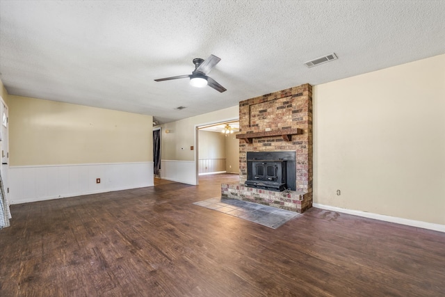 unfurnished living room with a fireplace, dark wood-type flooring, a textured ceiling, and ceiling fan