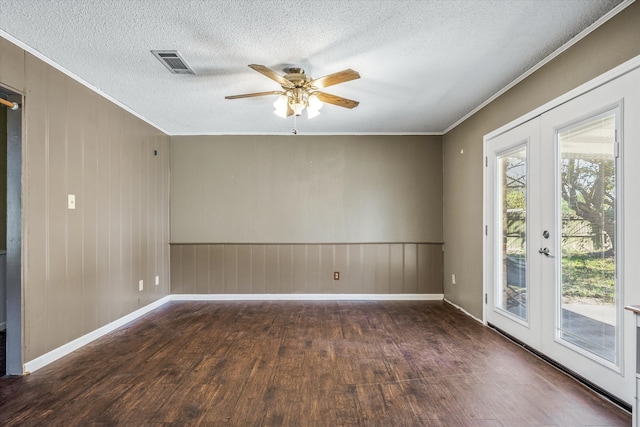 unfurnished room featuring french doors, dark wood-type flooring, ceiling fan, ornamental molding, and a textured ceiling