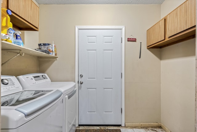 laundry room with a textured ceiling, cabinets, and washing machine and clothes dryer