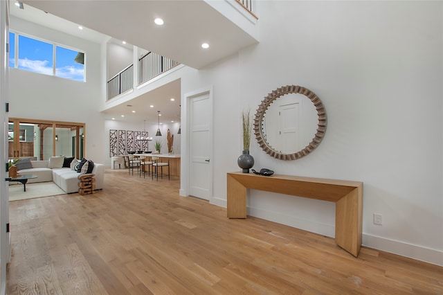 hallway featuring a high ceiling and light wood-type flooring