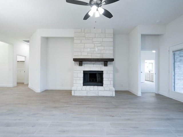 unfurnished living room with a fireplace, light wood-type flooring, and ceiling fan