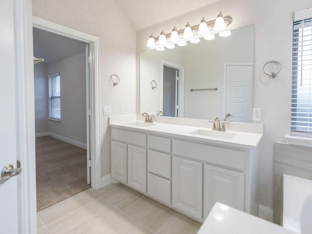 bathroom with tile patterned floors, vanity, and lofted ceiling