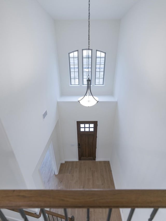 foyer entrance with wood-type flooring and high vaulted ceiling