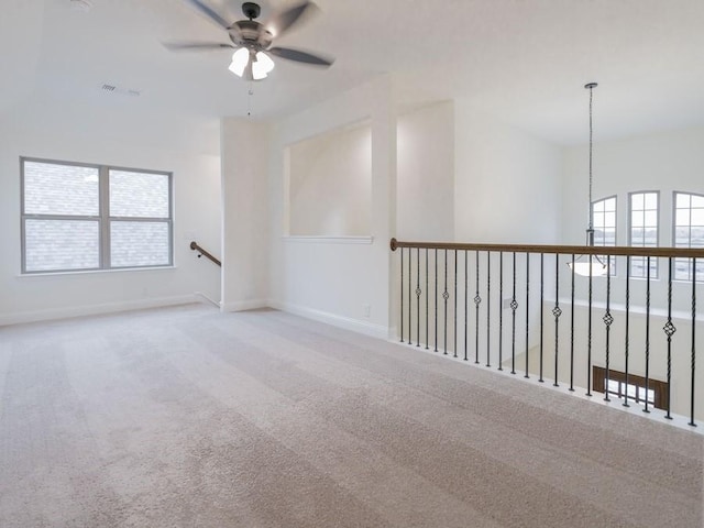 carpeted empty room featuring ceiling fan and a healthy amount of sunlight