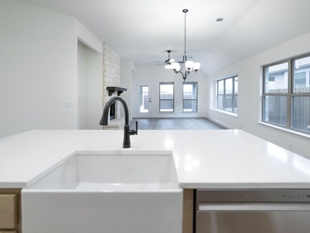 room details with a fireplace, sink, decorative light fixtures, a notable chandelier, and dishwasher