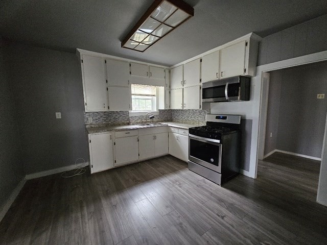 kitchen featuring sink, white cabinets, dark hardwood / wood-style floors, and appliances with stainless steel finishes