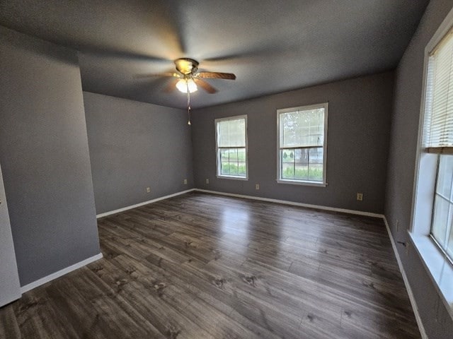 empty room with ceiling fan and dark wood-type flooring