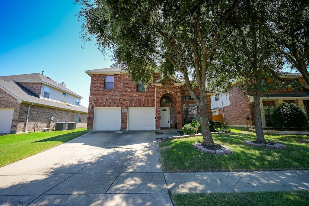 2541 Pinnacle Point Dr, Grand Prairie, TX 75054 - traditional-style house featuring brick siding, a front yard, cooling unit, a garage, and driveway