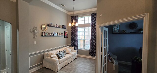 interior space with hardwood / wood-style floors, a notable chandelier, plenty of natural light, and crown molding