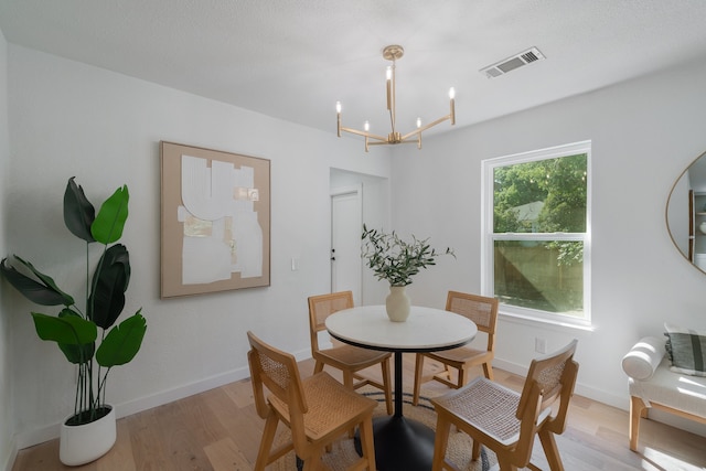 dining area featuring a notable chandelier and light hardwood / wood-style flooring