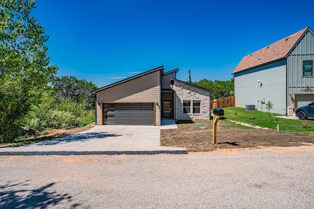 view of front of home with a garage and central AC