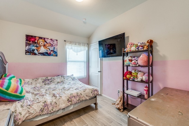 bedroom featuring light hardwood / wood-style flooring and vaulted ceiling