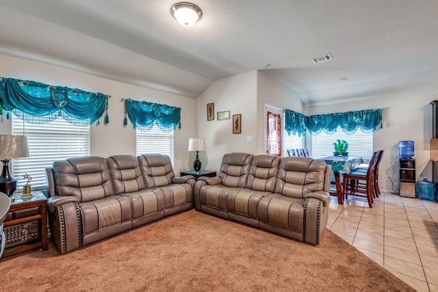 tiled living room with a textured ceiling and vaulted ceiling