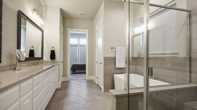 bathroom with vanity, tile patterned floors, and shower with separate bathtub