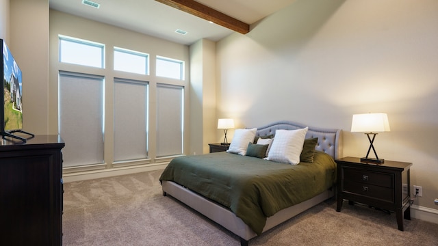 bedroom with light colored carpet and beamed ceiling