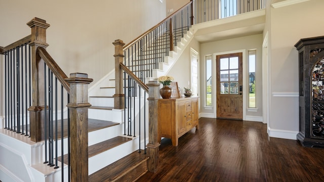 entrance foyer with ornamental molding, dark hardwood / wood-style flooring, and a high ceiling