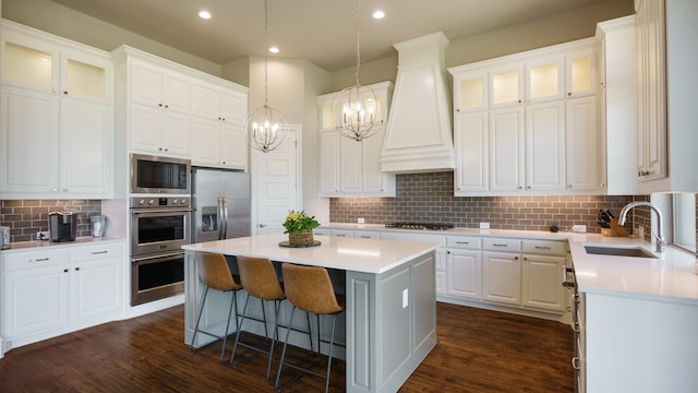 kitchen featuring a center island, a notable chandelier, premium range hood, and white cabinets