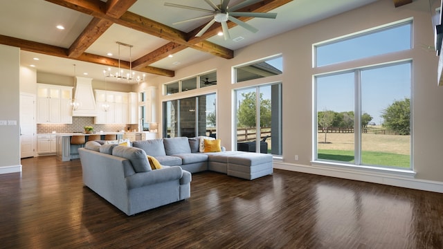 living room featuring plenty of natural light, ceiling fan with notable chandelier, and dark hardwood / wood-style flooring