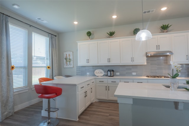 kitchen with dark wood-type flooring, white cabinets, and pendant lighting