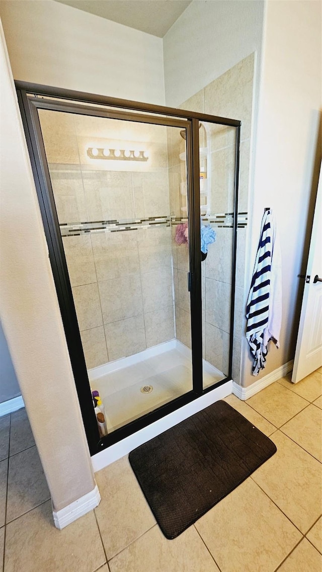 bathroom featuring tile patterned flooring and tiled shower