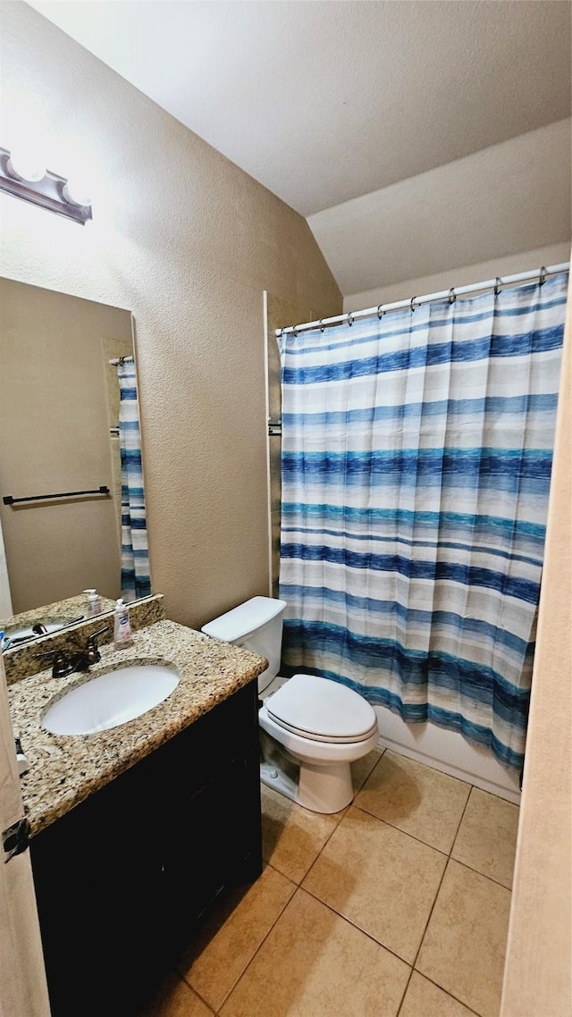 full bathroom with vanity, vaulted ceiling, tile patterned flooring, toilet, and shower / tub combo with curtain