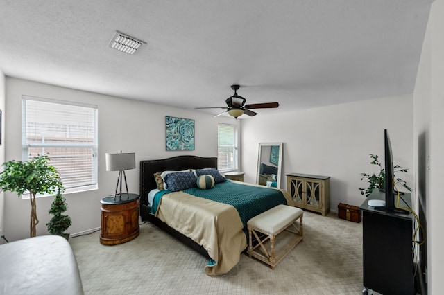 bedroom with carpet, ceiling fan, a textured ceiling, and multiple windows