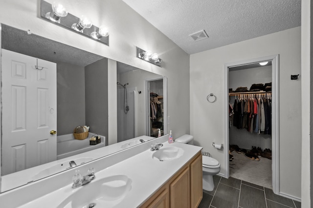 full bathroom with vanity, a textured ceiling, independent shower and bath, tile patterned flooring, and toilet