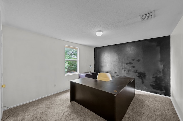 carpeted office featuring a textured ceiling