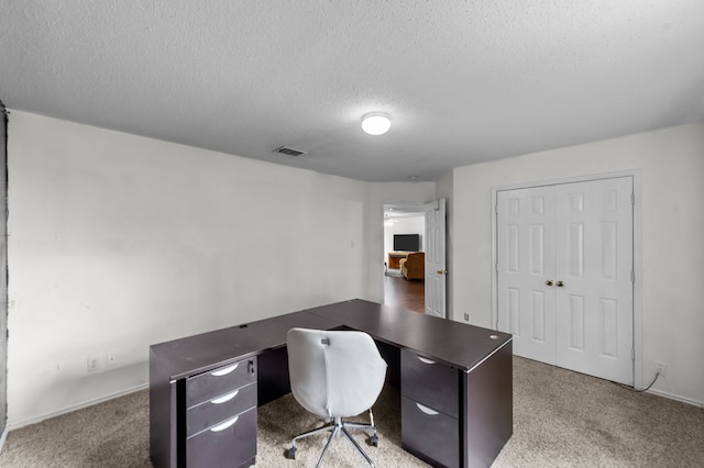 home office featuring carpet and a textured ceiling