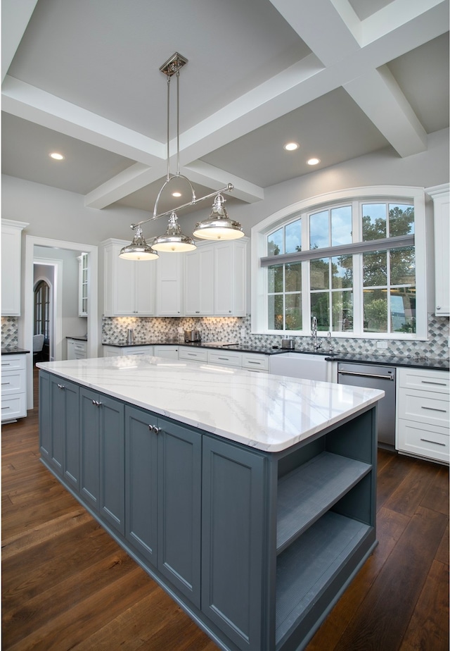 kitchen featuring white cabinets, light stone countertops, dark hardwood / wood-style flooring, decorative light fixtures, and stainless steel dishwasher