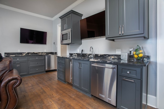 kitchen featuring appliances with stainless steel finishes, crown molding, dark hardwood / wood-style flooring, and gray cabinets