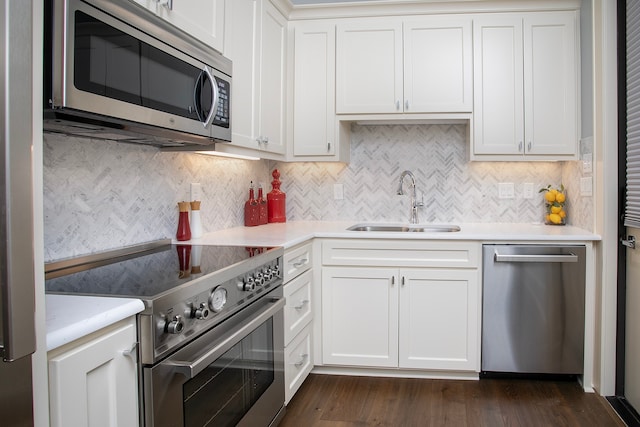 kitchen featuring white cabinets, sink, dark wood-type flooring, appliances with stainless steel finishes, and decorative backsplash