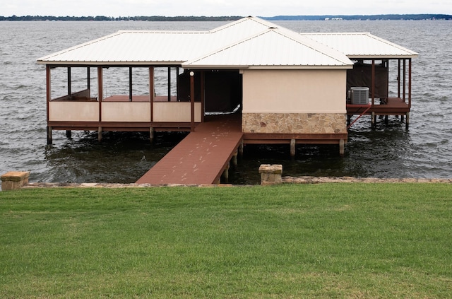 view of dock featuring a water view, central air condition unit, and a yard