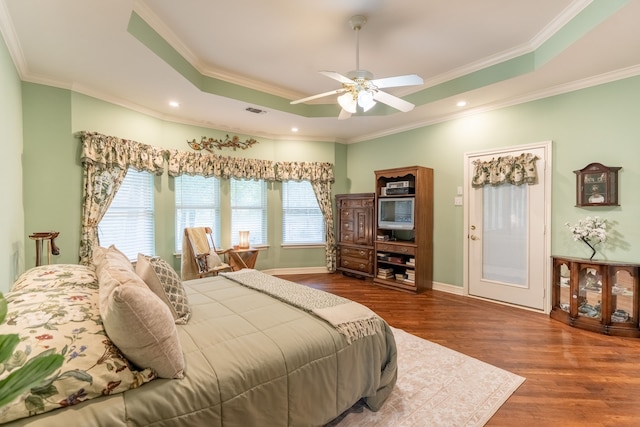 bedroom with a raised ceiling, ceiling fan, wood-type flooring, and ornamental molding