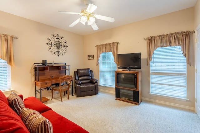 living room featuring ceiling fan, carpet floors, and a wealth of natural light