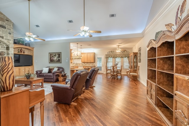 living room featuring hardwood / wood-style flooring, ceiling fan with notable chandelier, ornamental molding, and vaulted ceiling