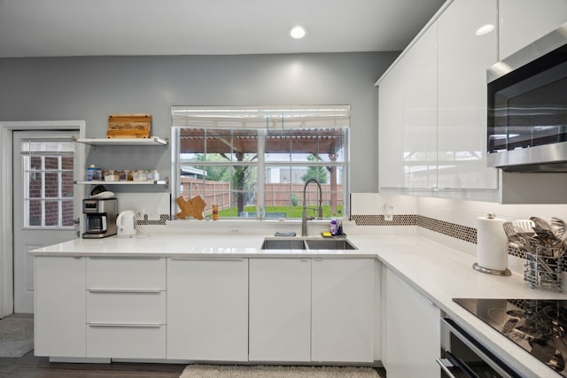 kitchen featuring hardwood / wood-style flooring, sink, stainless steel appliances, and white cabinets