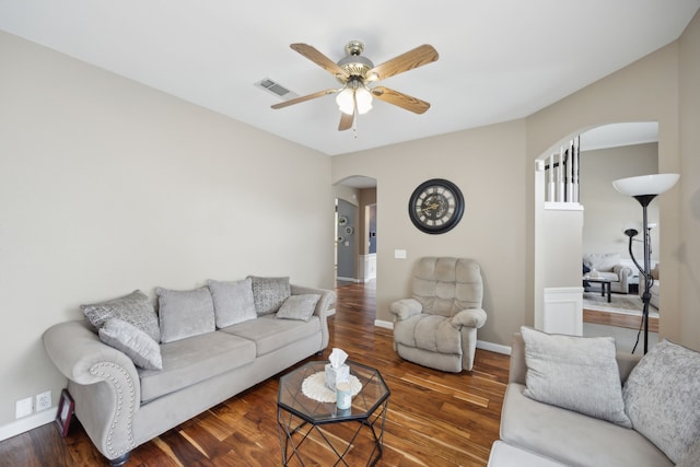 living room with ceiling fan and dark wood-type flooring