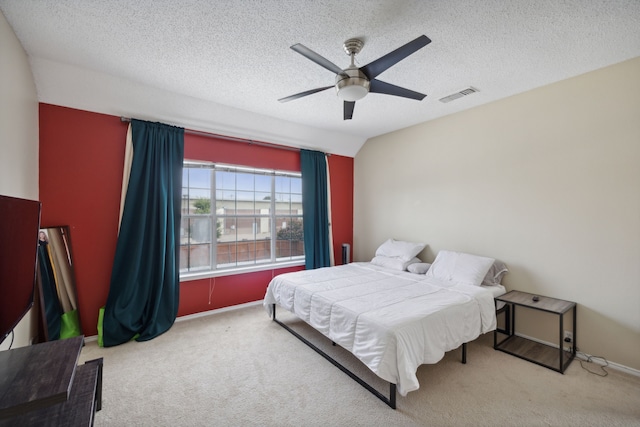 carpeted bedroom featuring ceiling fan, a textured ceiling, and vaulted ceiling