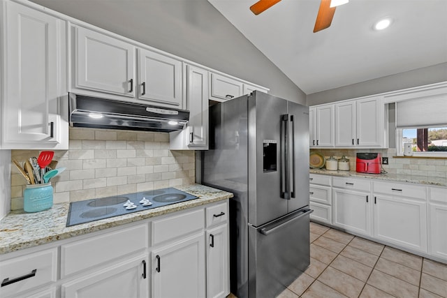 kitchen featuring white cabinetry, black electric cooktop, stainless steel fridge, and vaulted ceiling