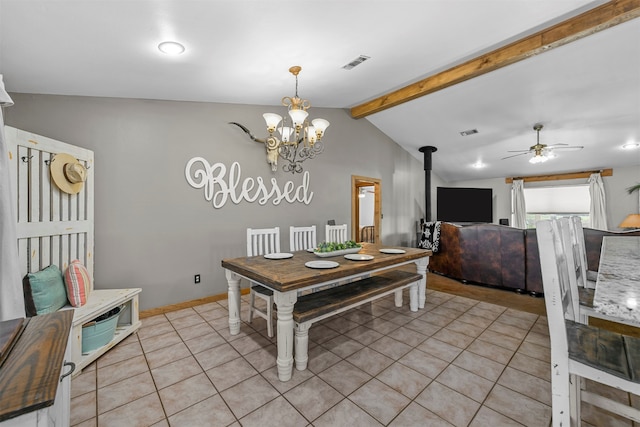 dining room with a wood stove, lofted ceiling with beams, ceiling fan with notable chandelier, and light tile patterned floors