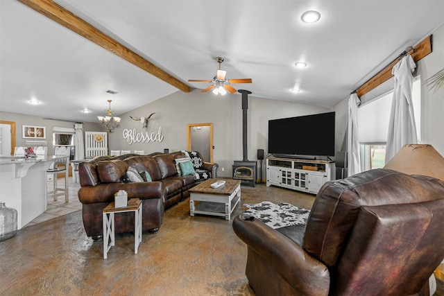 living room featuring lofted ceiling with beams, ceiling fan with notable chandelier, and a wood stove