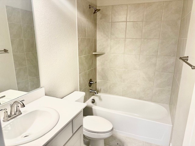 full bathroom featuring toilet, vanity, and tiled shower / bath